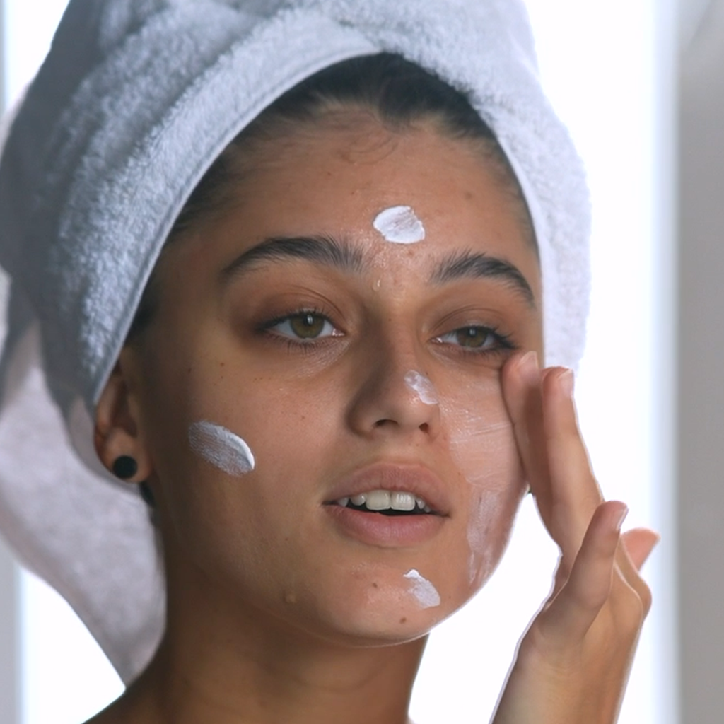 woman applying Age Defying Sol